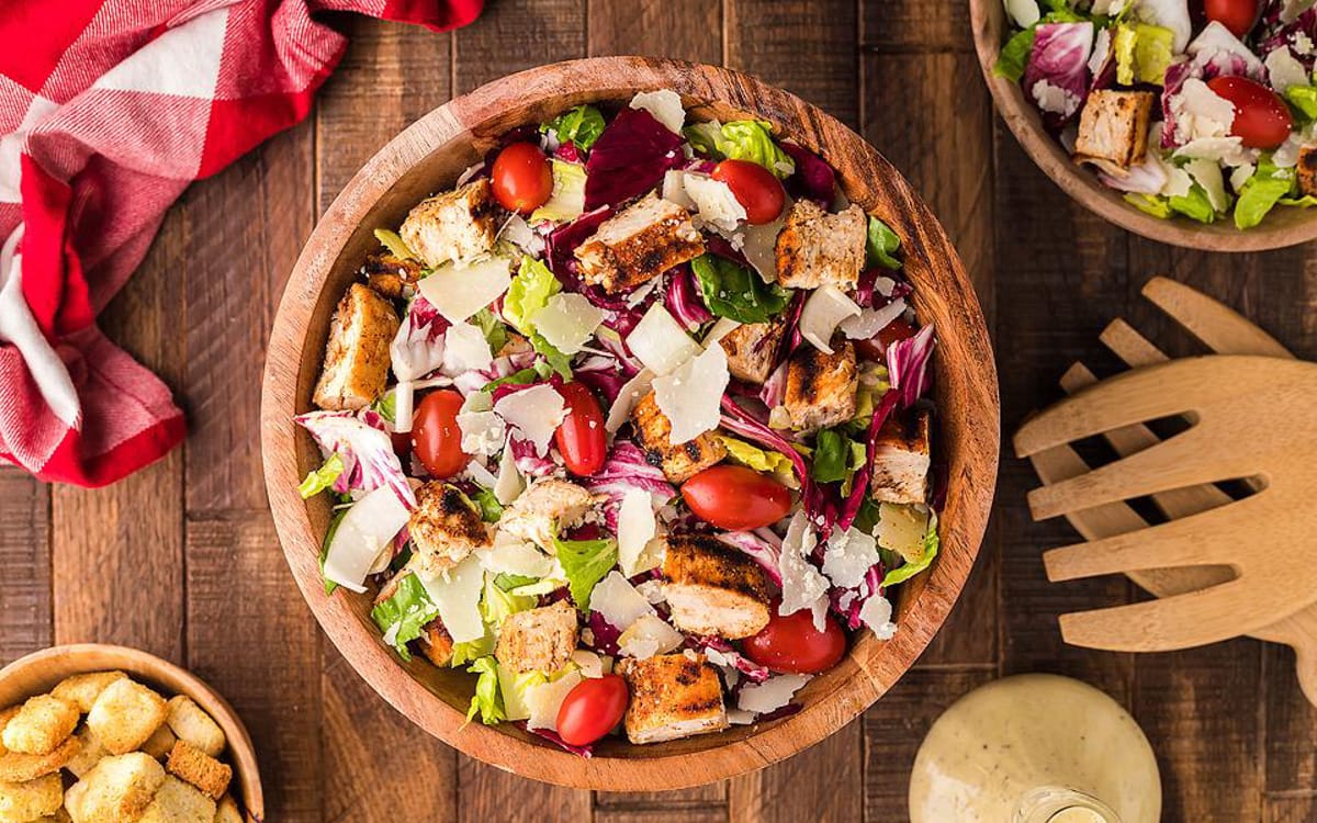 Endive salad with vegetables in a brown bowl.