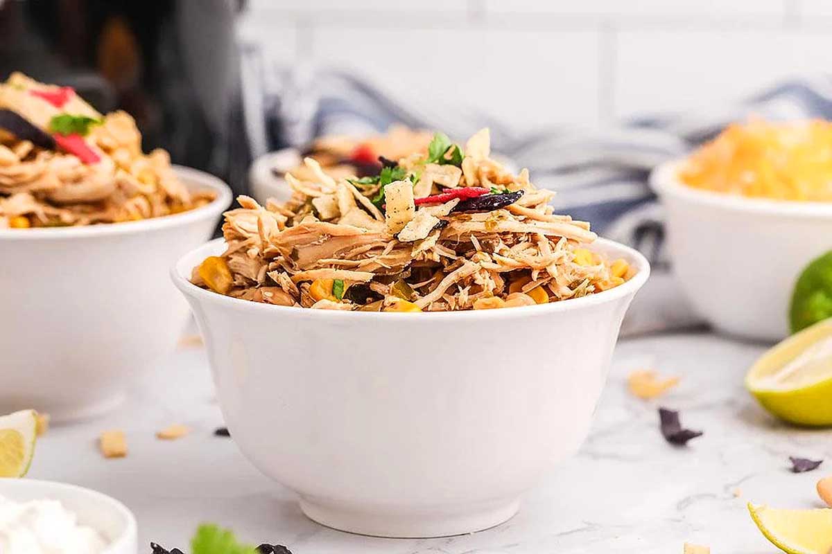 Chicken soup piled high in a white bowl.