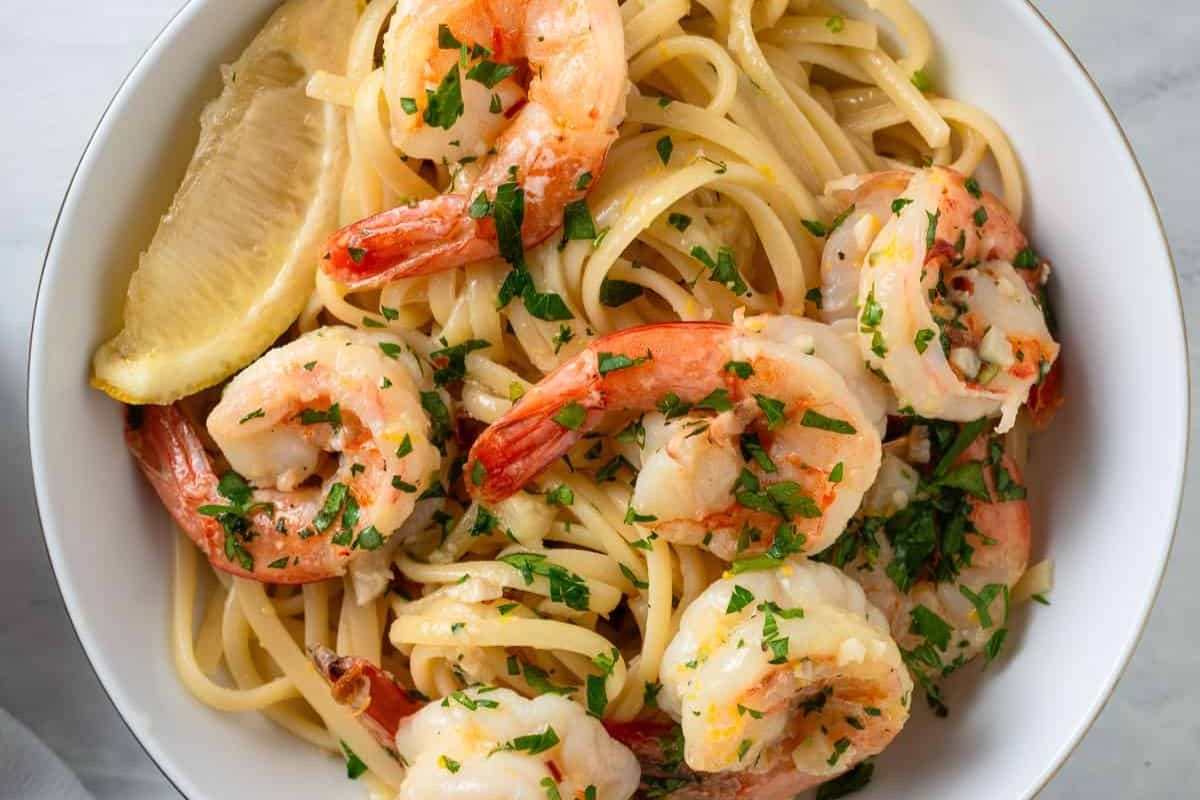 Pasta with shrimp on top.