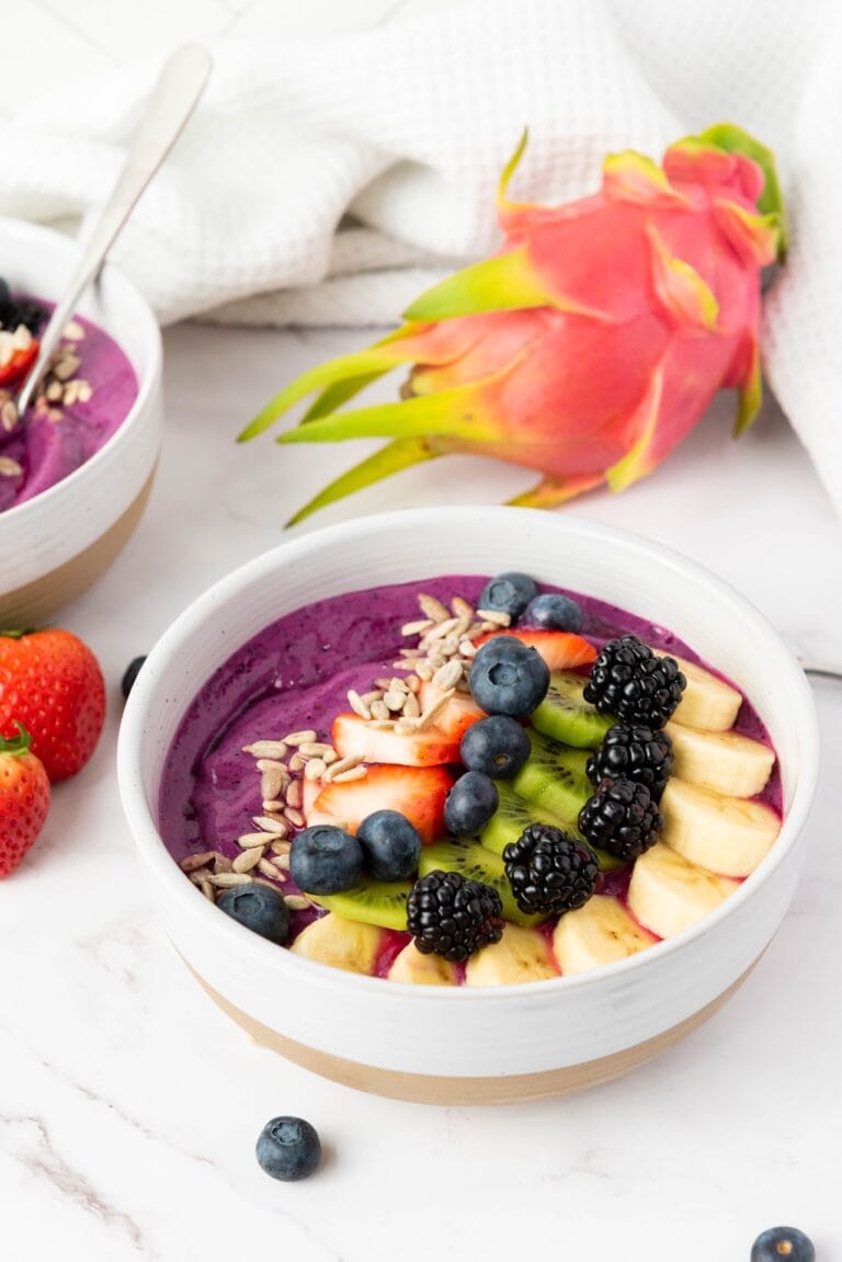 smoothie in a bowl with fruit on the side