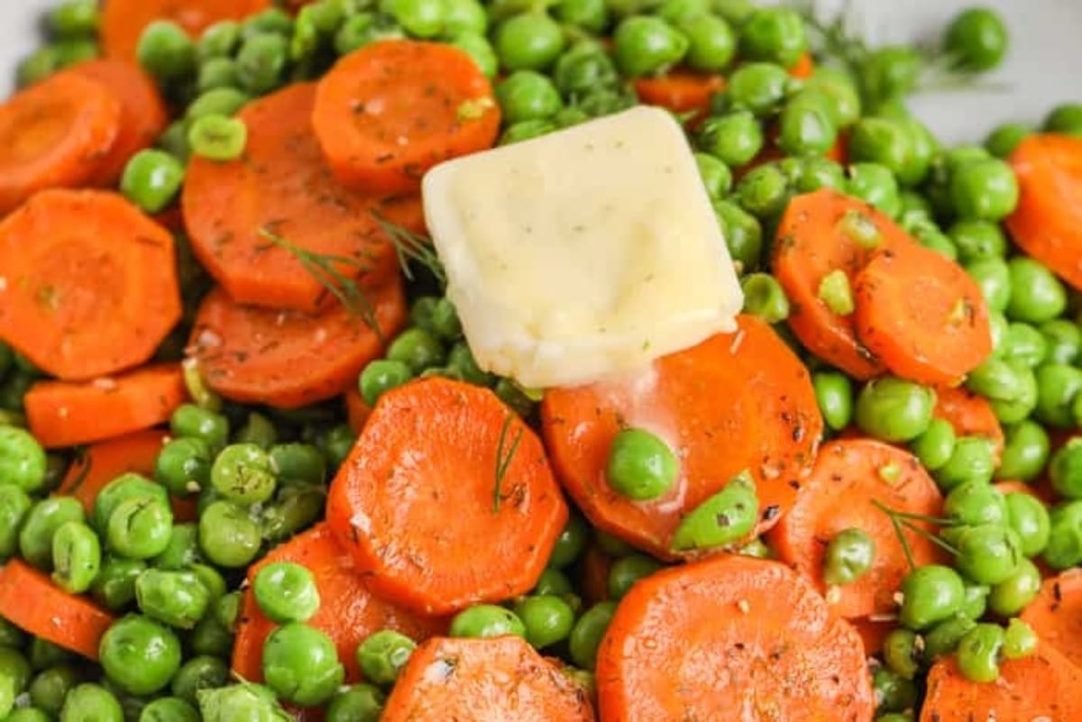 Peas, carrots and butter on a plate.