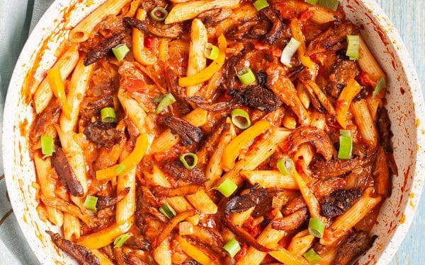 Cajun pasta in a bowl with red sauce.