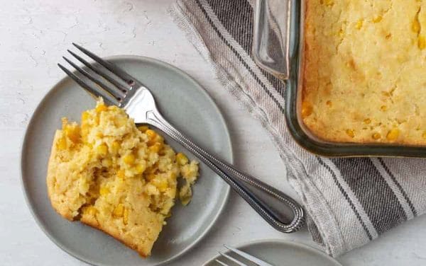 Corn casserole on a gray plate with a fork.