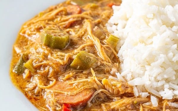 Gumbo with rice in a blue bowl.