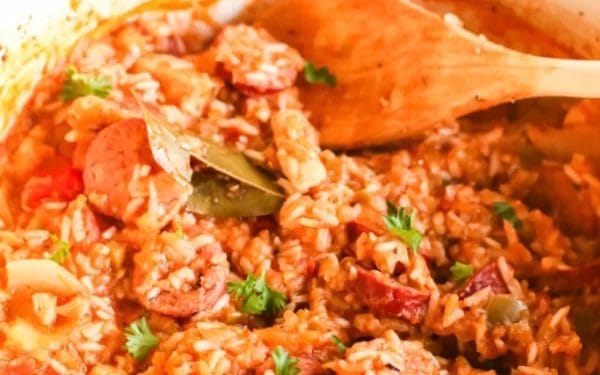 Chicken jambalaya with rice and a wooden spoon.