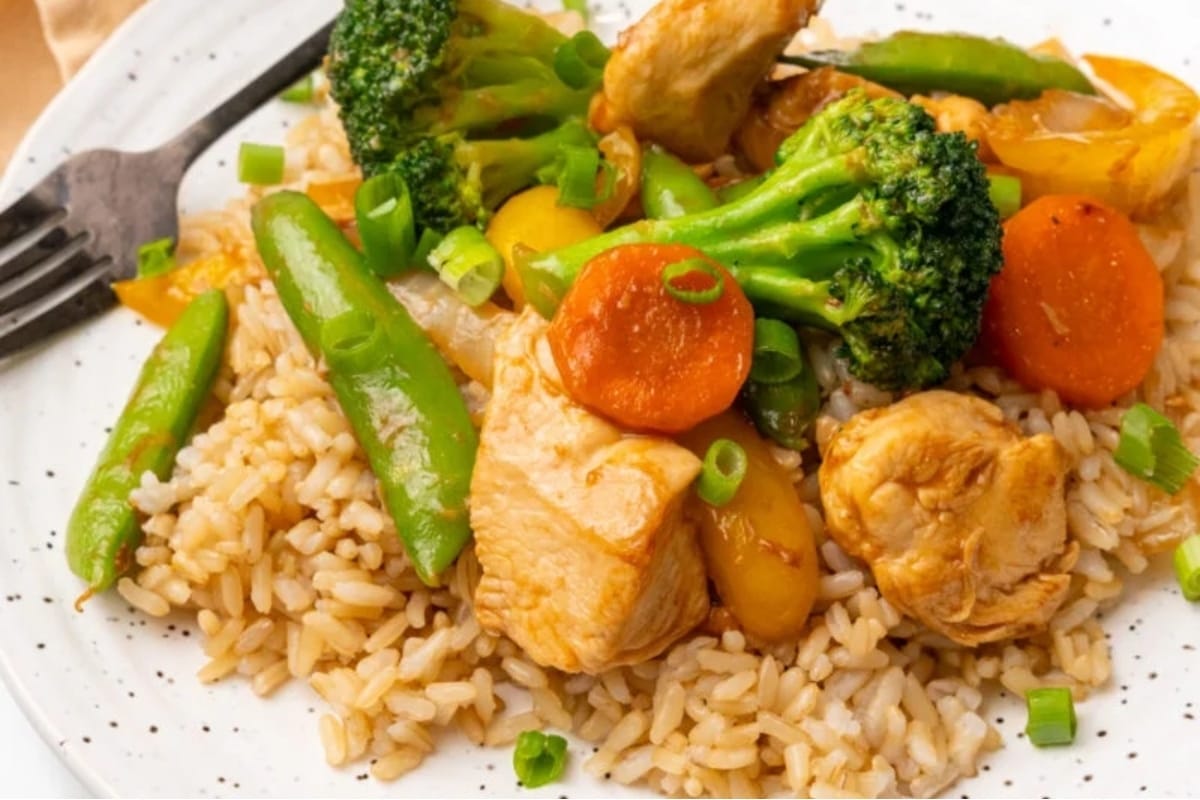 A white plate with rice, broccoli and carrots.