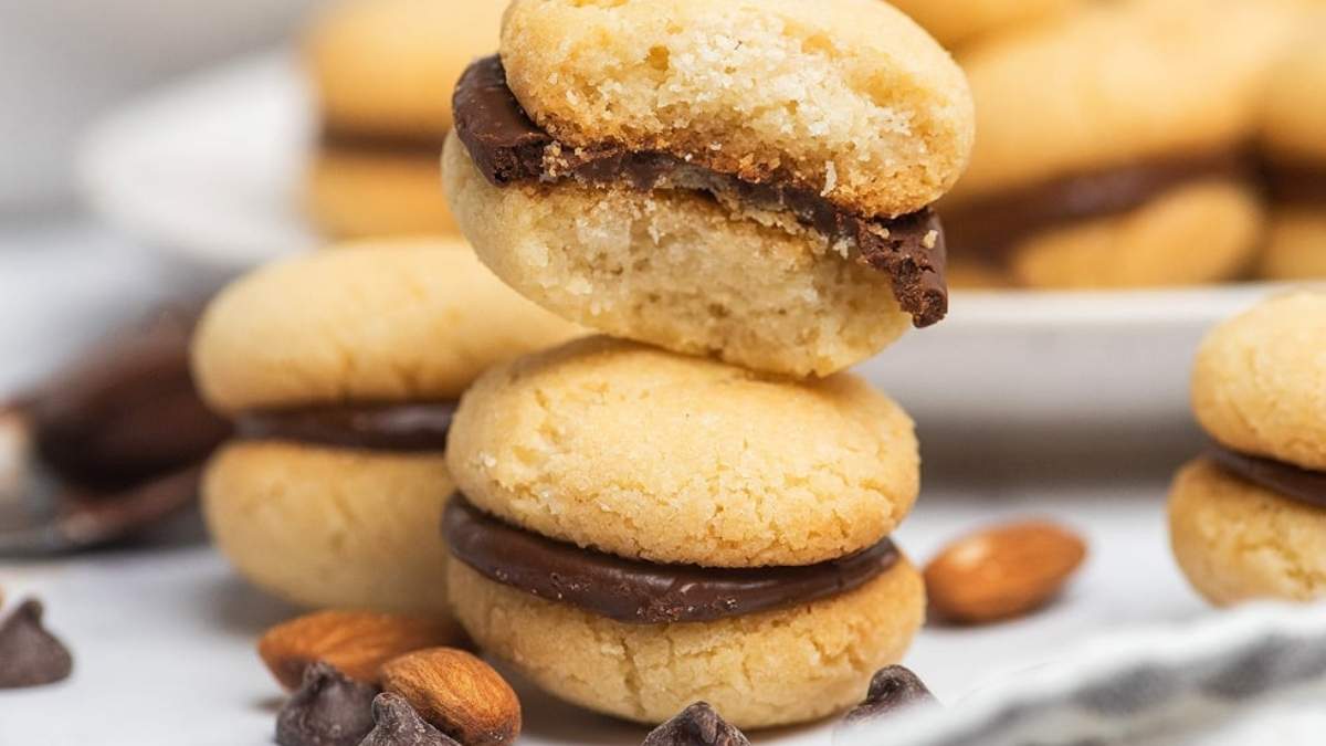 A stack of chocolate almond cookies on a white plate, perfect for indulging in delicious homemade cookie recipes.