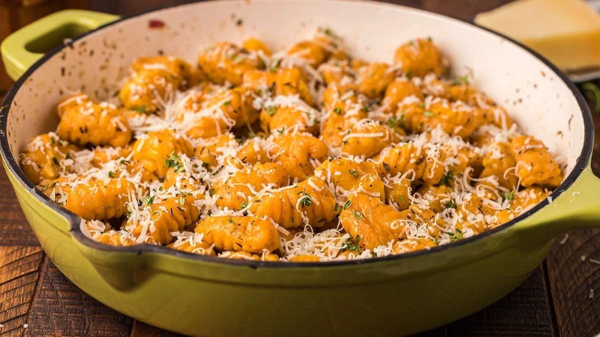 Comfort Food Recipes: Cheesy gnocchi in a green pot with parmesan cheese.