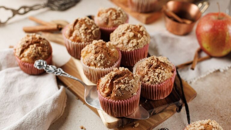 Seven muffins on a wooden board.