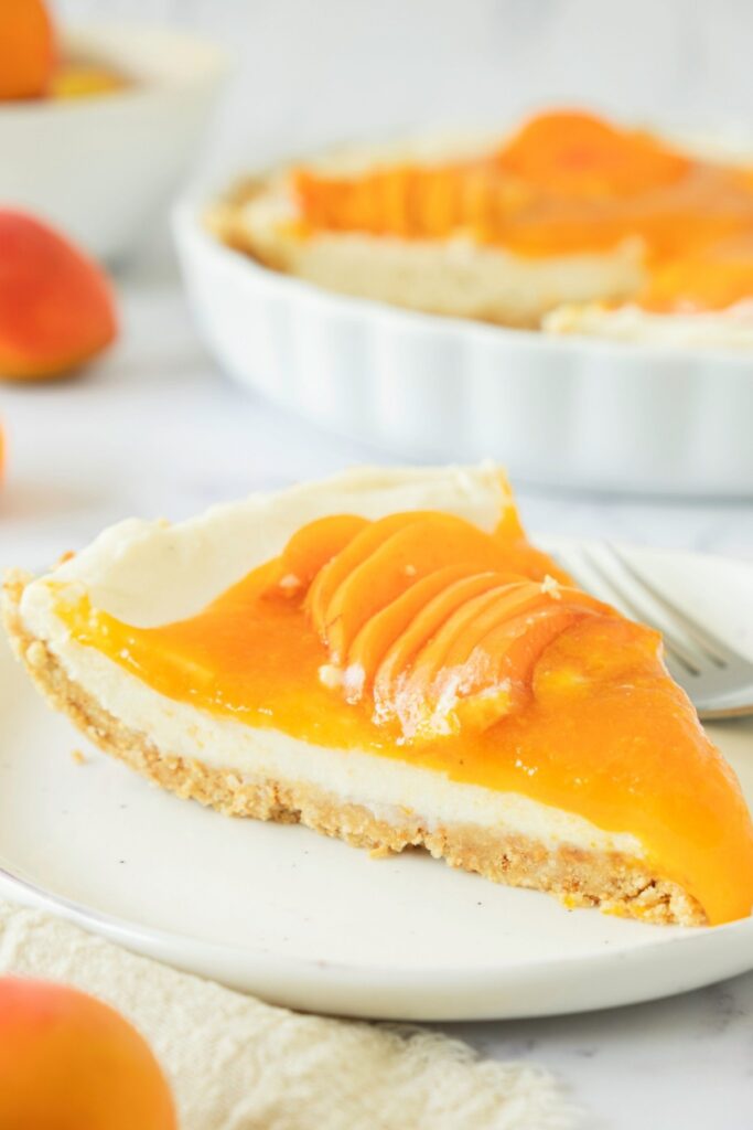 A slice of apricot cheesecake on a plate.