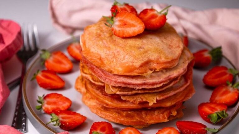 Stack of pancakes with fresh strawberries.