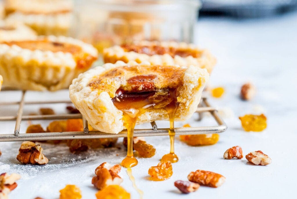 A gooey butter tart with a bite out of it on a wire rack. This is one of the best Canadian recipes.